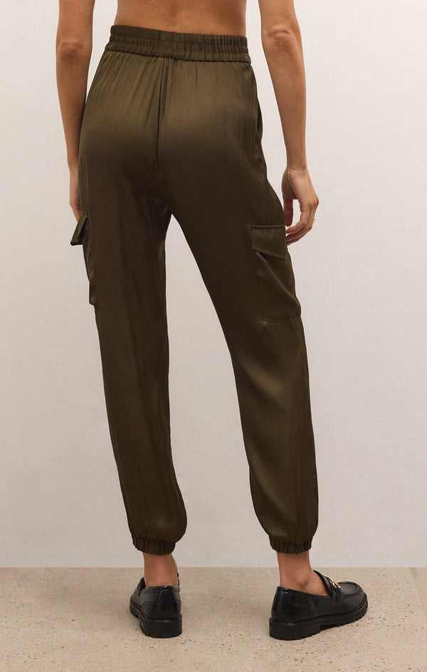 back view of model wearing Rory cargo jogger in kelp. shows the elastic waistband. also shows the tapered, jogger cuffs, and the side cargo pockets. 
