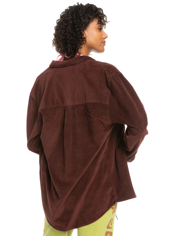 Back view of model wearing the let it cord. Shows the collar. Also shows the back is little bit longer than the front. Shows the long sleeves and drop hem on the shoulders. 