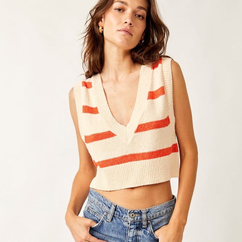 front view of the Santa Monica vest in this cream color with orange stripes. shows the deep v neckline. also shows the cropped length, the ribbed detail on the neckline, hem and sleeves.
