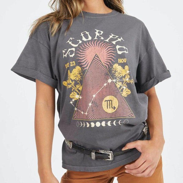 Front view of model wearing tee. Shows the crew neckline. Also shows the cuff sleeves, distressing on neckline and the scorpio zodiac graphic. 