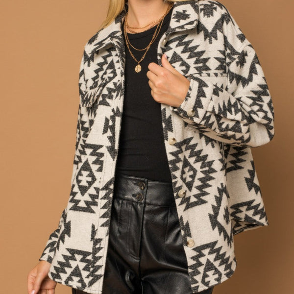 Front view of model wearing shacket. Shows the button closure.  Also shows the collar and the two front pockets. 