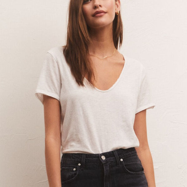 front view of model in white tee. shows the low scoop neckline and loose fit. 