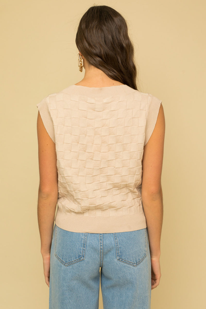 shows back view of model in the vest. shows the sleeveless design, contrast ribbing on the hems and arms and the bigger fit.