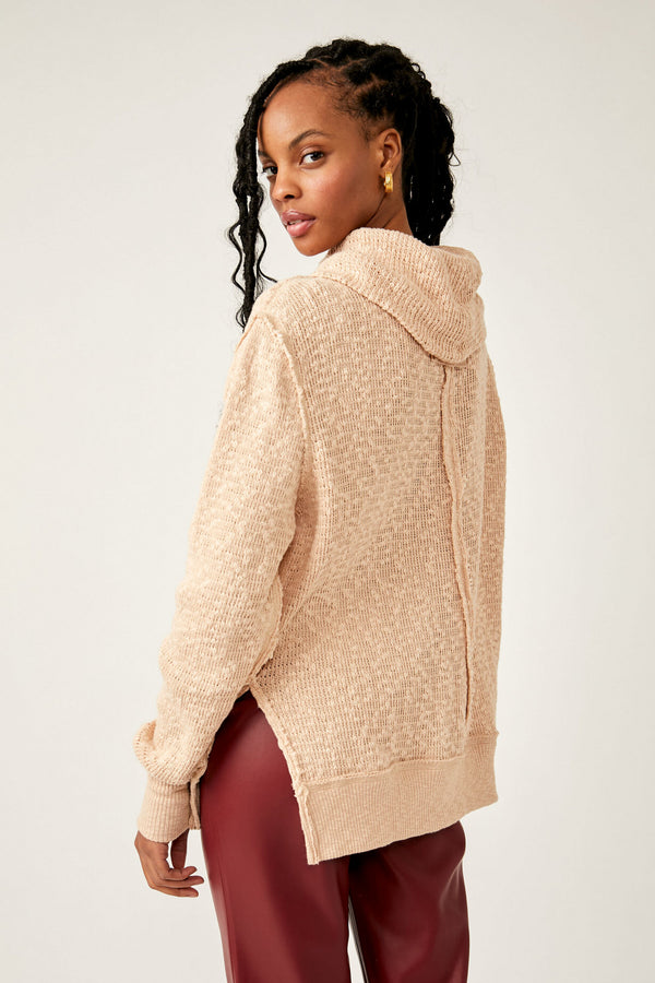 Back view of model wearing turtleneck. Shows the turtleneck. Also shows the side slits, the dropped shoulders ribbed hems and the defined seaming down the back in this beautiful cream/khaki color. 