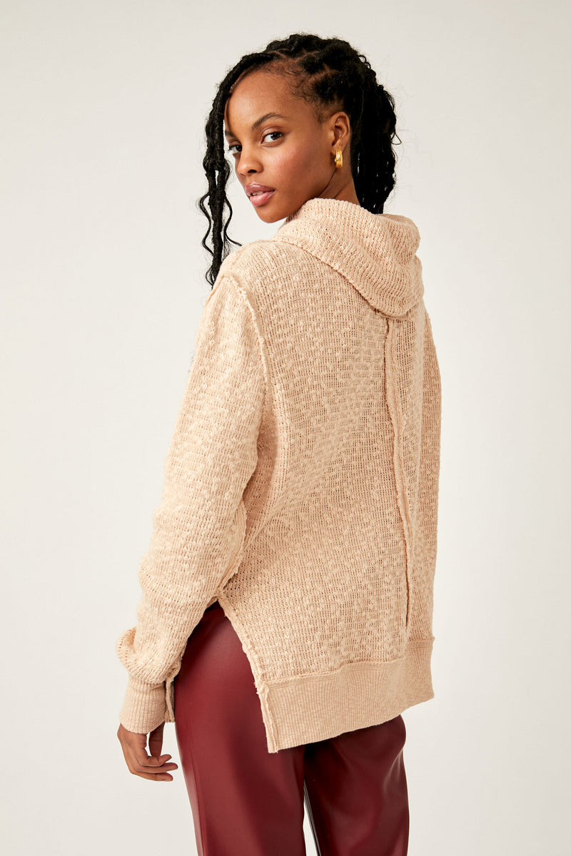 Back view of model wearing turtleneck. Shows the turtleneck. Also shows the side slits, the dropped shoulders ribbed hems and the defined seaming down the back in this beautiful cream/khaki color. 