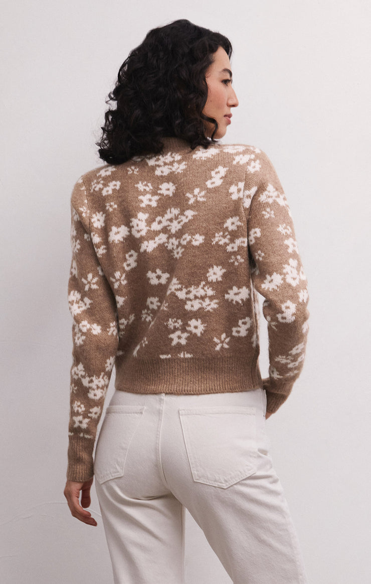 Back view of model wearing sweater. Shows the fitted style. Also shows the ribbing detail on the fitted bottom band and cuffs. Also shows the abstract flower print and the campfire color with cream flowers.