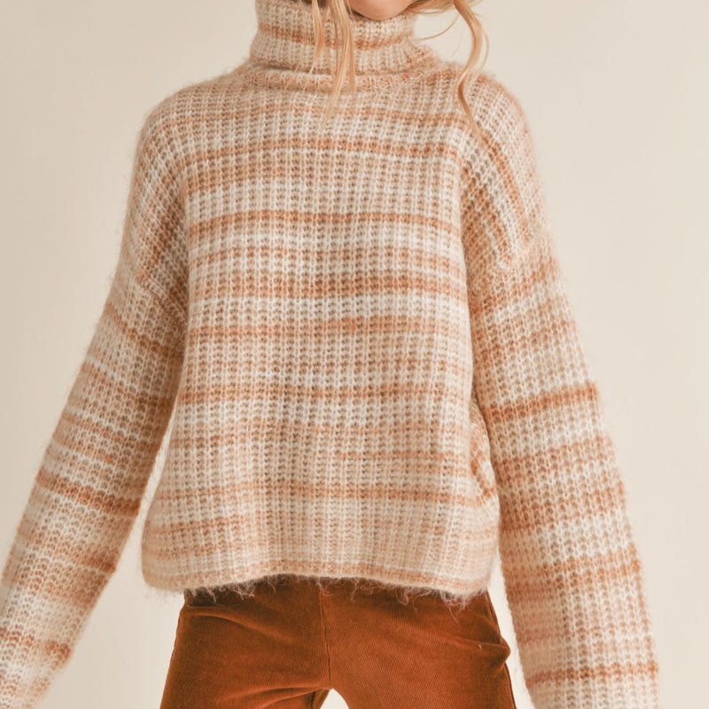 front view of the Loretta sweater in cream multi. shows the turtleneck. also shows the striping detail, the wider sleeves and the oversized fit. 