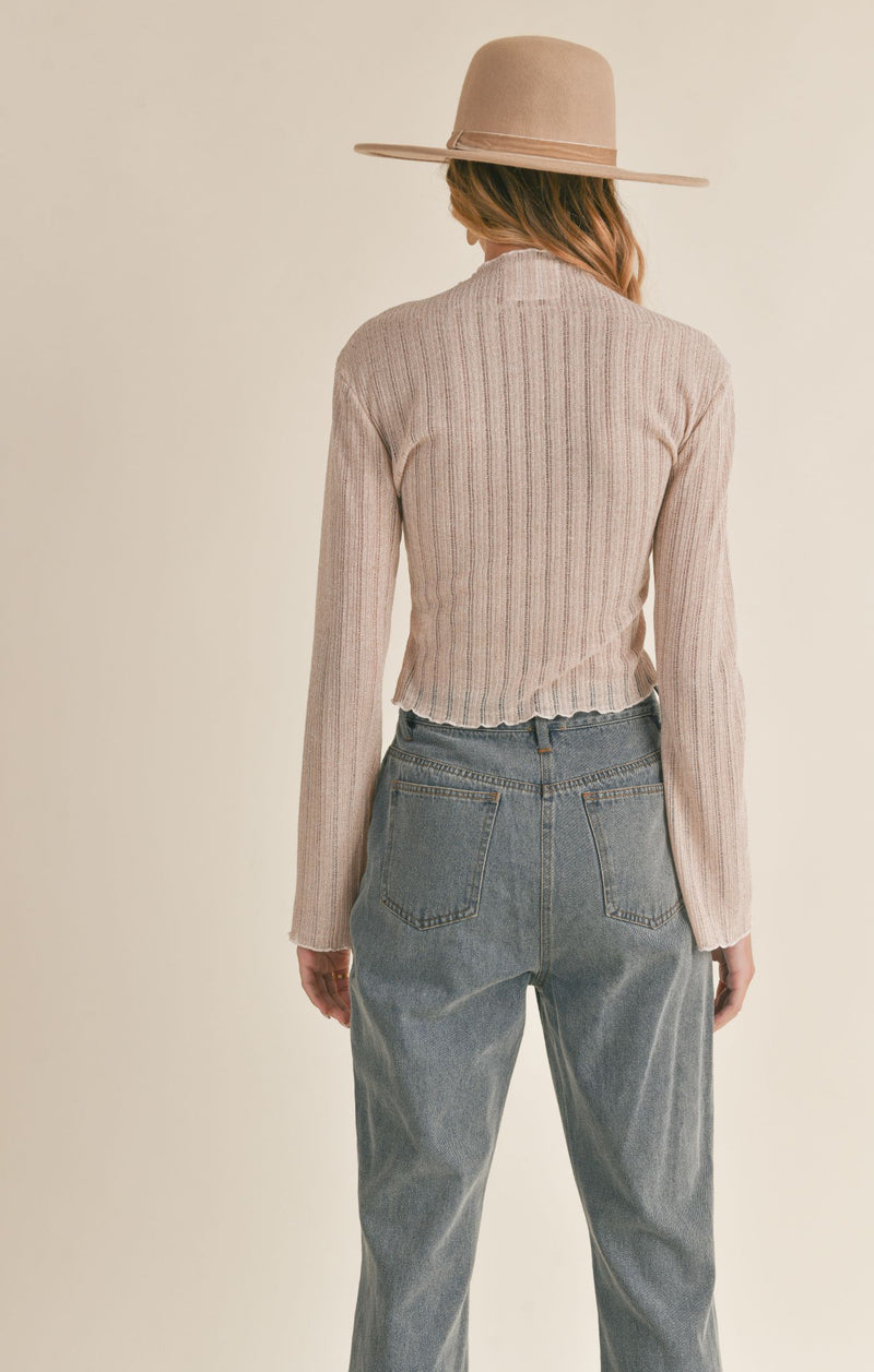 back view of model wearing splendid top. shows the lettuce trim throughout. also shows the flared sleeves, the slight mock neck and slim fit. 