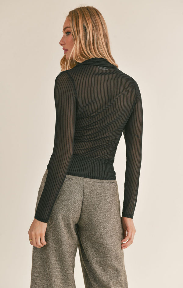 back view of the model wearing the lady dynamite shirt in black. shows the slim fit. also shows the line detailing throughout the sheer fabric and the collared neckline. 