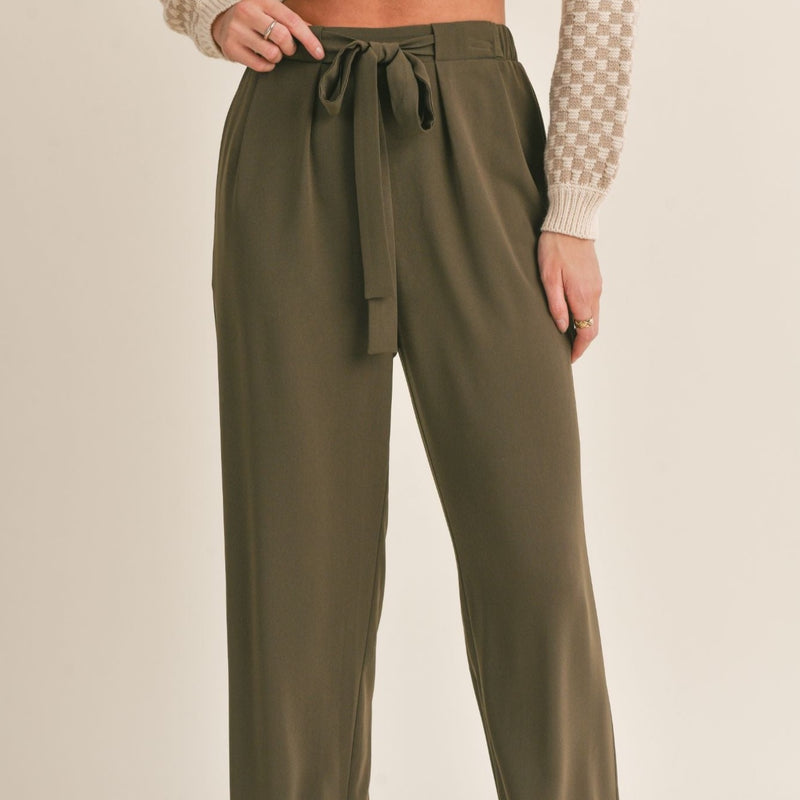 front view of the model wearing the new rules wide leg pants in dark olive. shows the tie waist. also shows the side pockets and the high waist of the pant. 