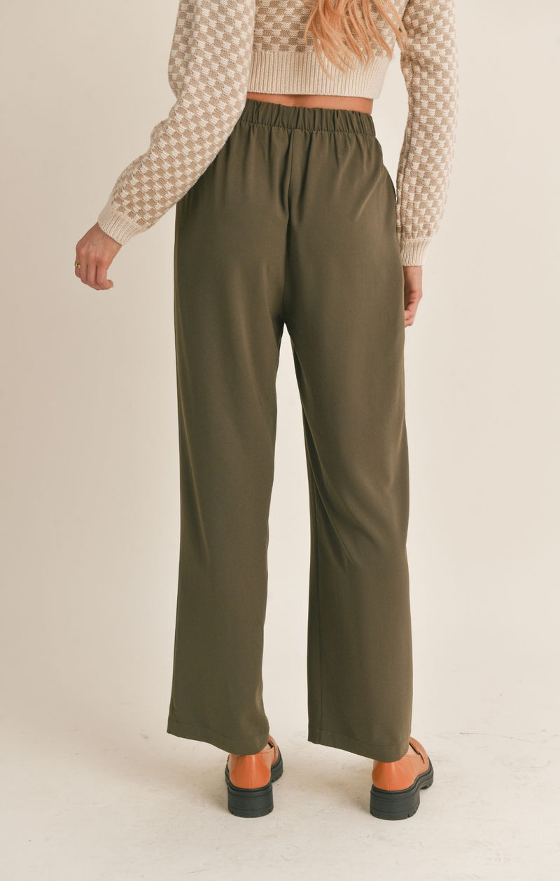 back view of the model wearing the new rules wide leg pants in dark olive. shows the wide leg. the back elastic waist and the high waist of the pant. 