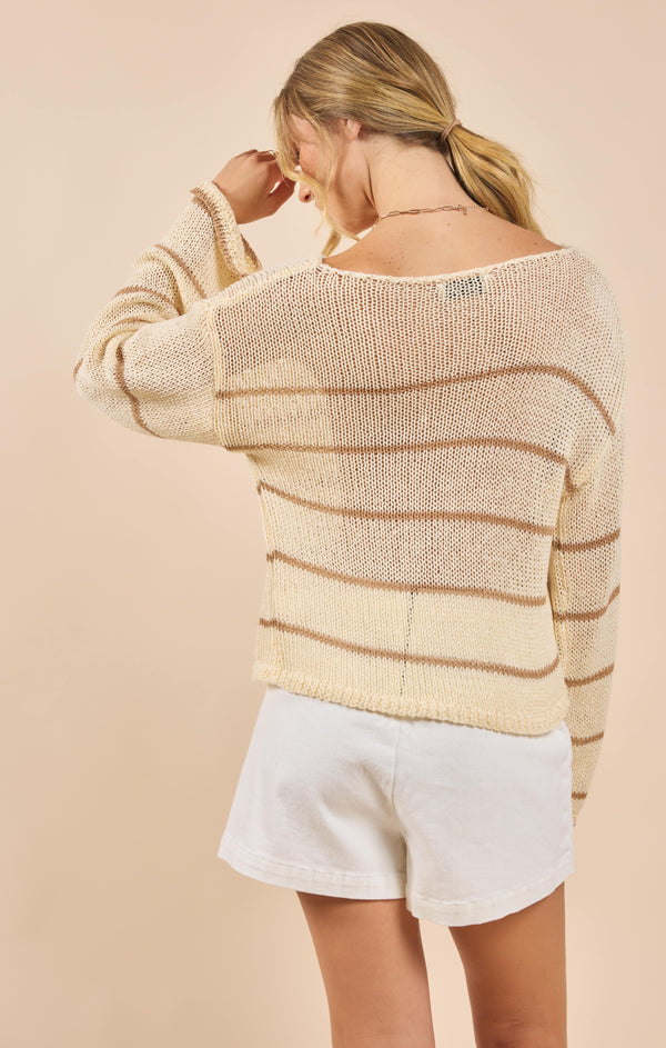back view of the model wearing the taylor striped knit sweater. shows the wide neckline. also shows the stripes, the sheer fabric and dropped shoulders. 