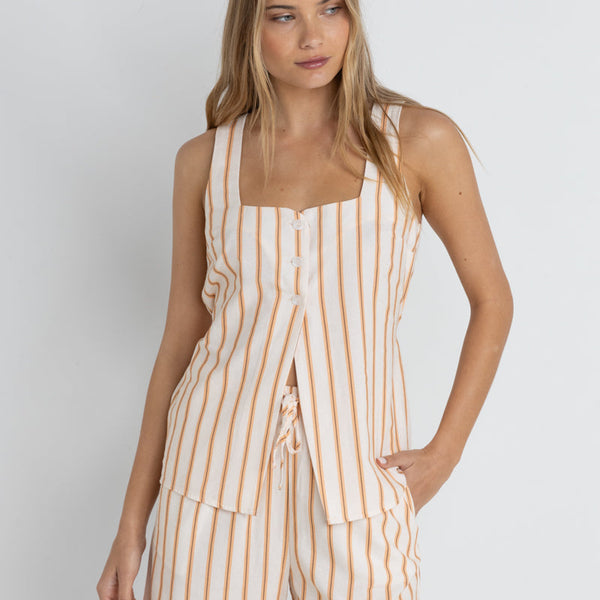 front view of the model wearing the tide stripe long vest. shows the square neckline. also shows the 3 button closure, the long length, the vertical stripes. 