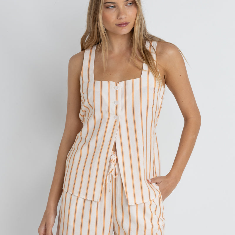 front view of the model wearing the tide stripe long vest. shows the square neckline. also shows the 3 button closure, the long length, the vertical stripes. 