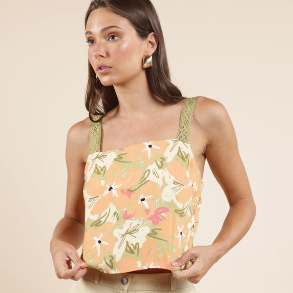 front view of the model wearing the aperitivo lacey back tied top. shows the lace straps. also shows the floral print, the square neckline and the floral print. 