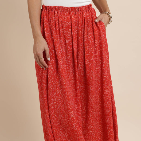 front view of the model wearing the nina midi skirt. shows the elastic waistband. also shows the red color and the white polka dot detailing. 