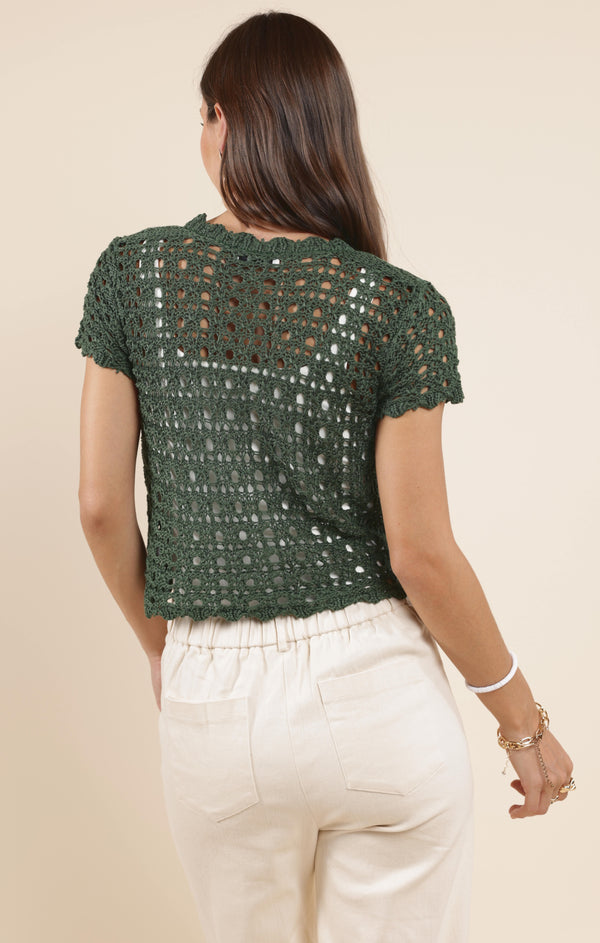 back view of the model wearing the mercer crochet cardigan. shows the green color. also shows the crochet detailing, the short sleeves and the semi cropped length. 