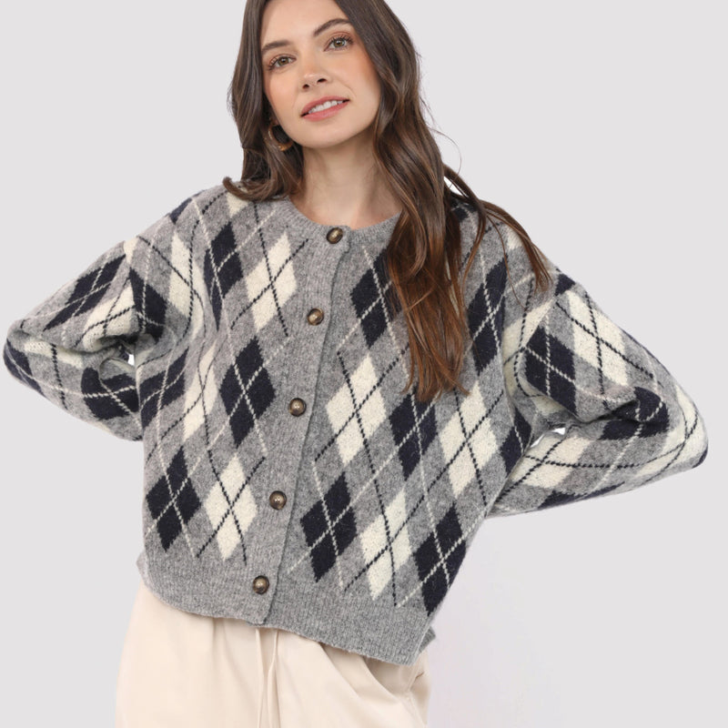 Woman wearing a plaid cardigan with a plain background