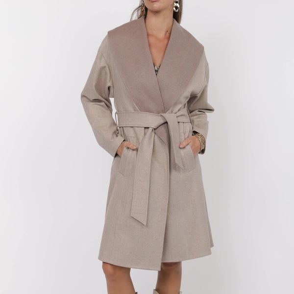 Woman wearing a beige trench coat and boots on a white background