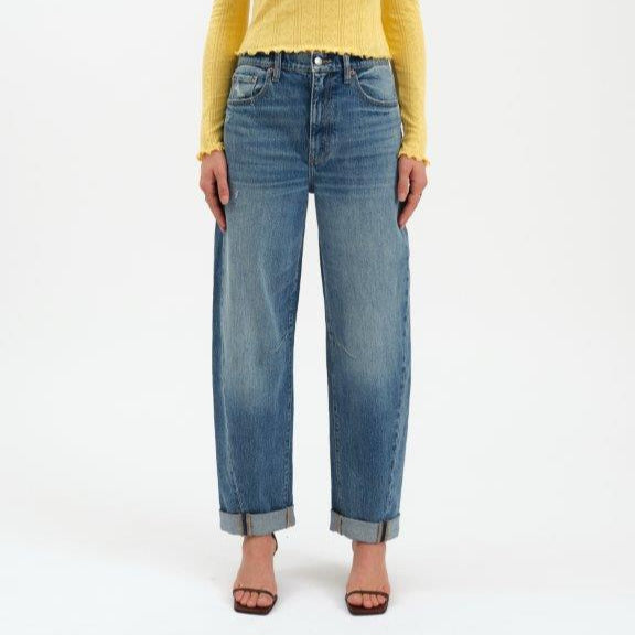 Person wearing a yellow sweater and blue jeans on a white background