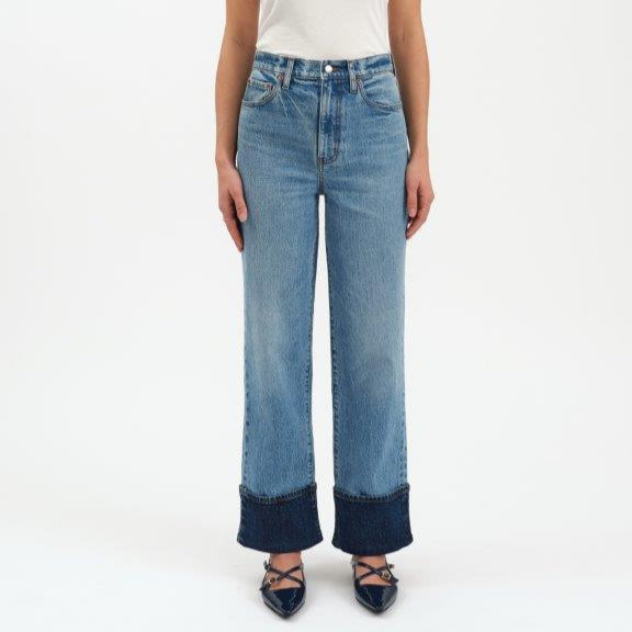 Person wearing blue jeans with white shirt on a white background
