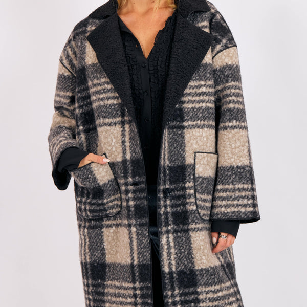Woman wearing a plaid coat on a white background