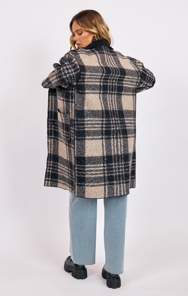 Person wearing a plaid coat on a white background