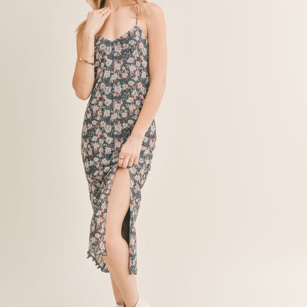 Front view of model midi dress. Shows the front side slit. Also shows the low neckline and bottom lettuce style hem. 