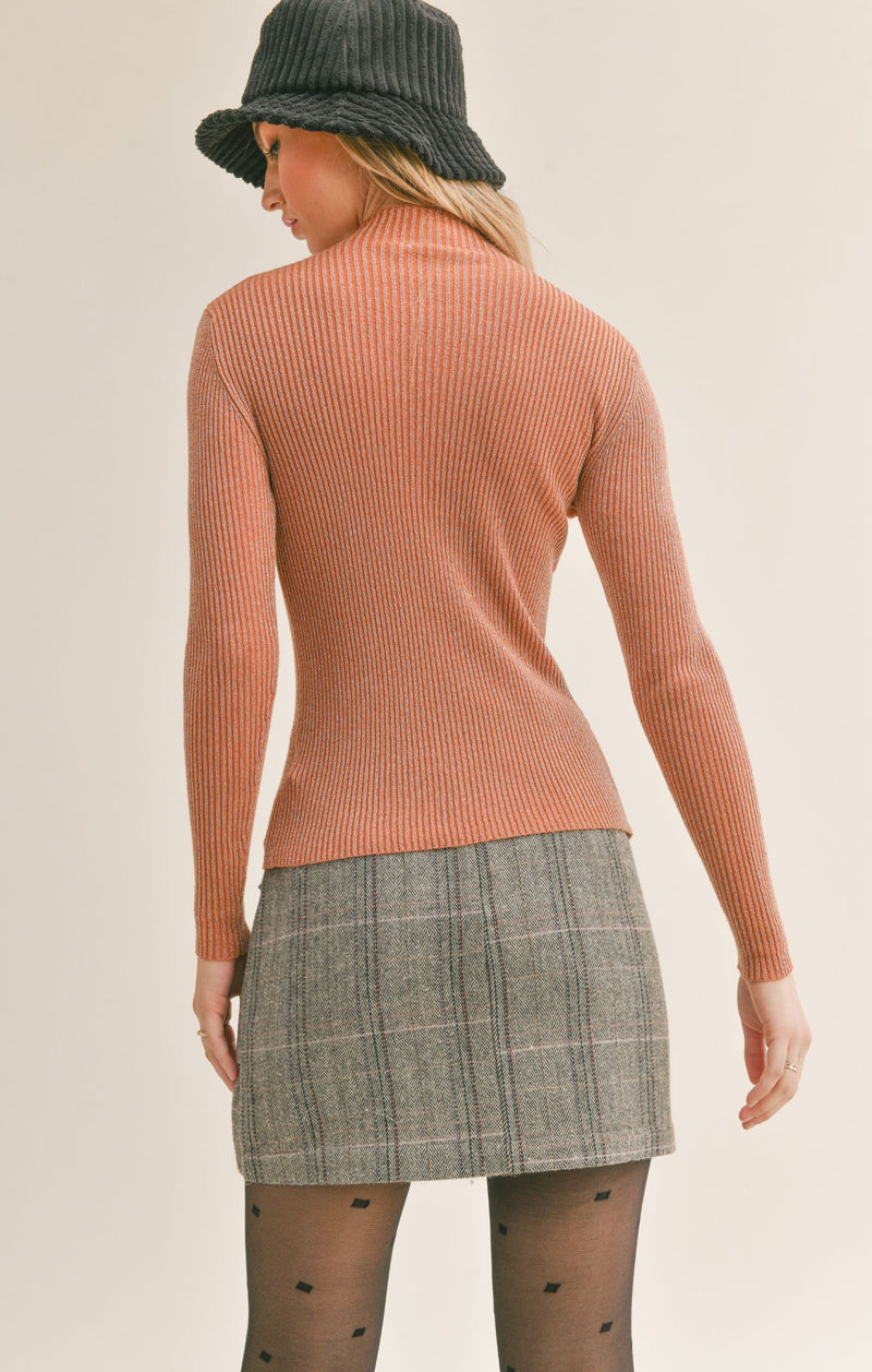 Back view of model wearing sweater. Shows the mock neck. Also shows the ribbed detail throughout and that it is more fitted. 