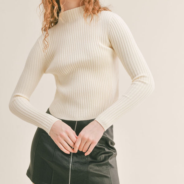 Front view of model wearing sweater. Shows the mock neck. Also shows the ribbed knit detail and the long sleeves. 