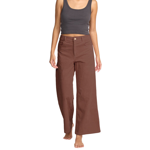 Woman wearing a gray tank top and brown pants on a white background