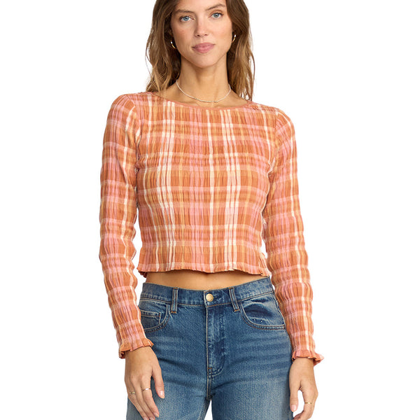 Woman wearing a plaid long-sleeve top and jeans on a white background