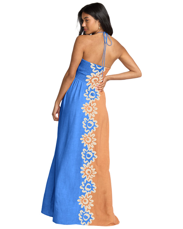 Woman wearing a blue and orange dress with floral patterns on a white background