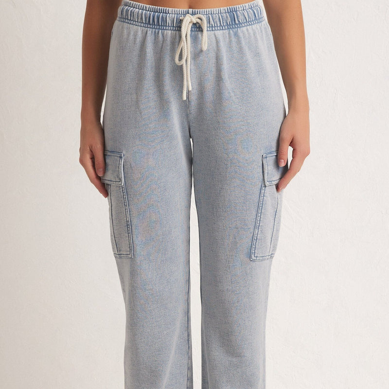 front view of the model wearing the tempo knit denim jogger. shows the drawstring. also shows the relaxed fit, and the side cargo pockets. 
