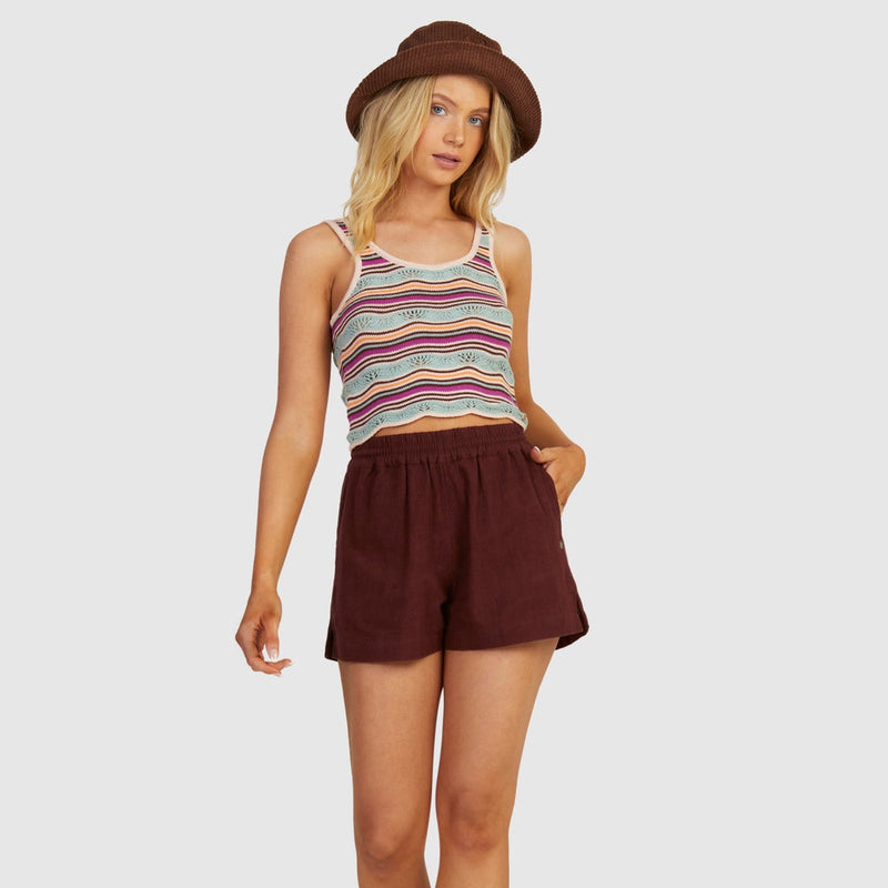 front view of model in tank top. shows scoop neckline, multi color stripes, knit fabrication and a scalloped hemline.