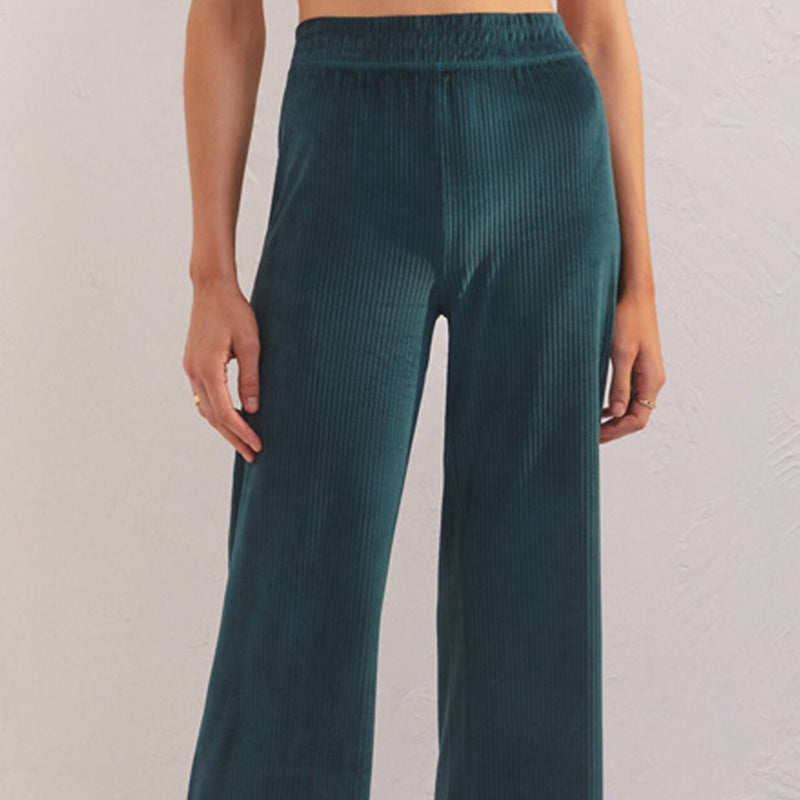 Front view of model wearing pants. Shows the stretchy waistband. Also shows the high waist, the ribbed detail throughout and the rich pine color.