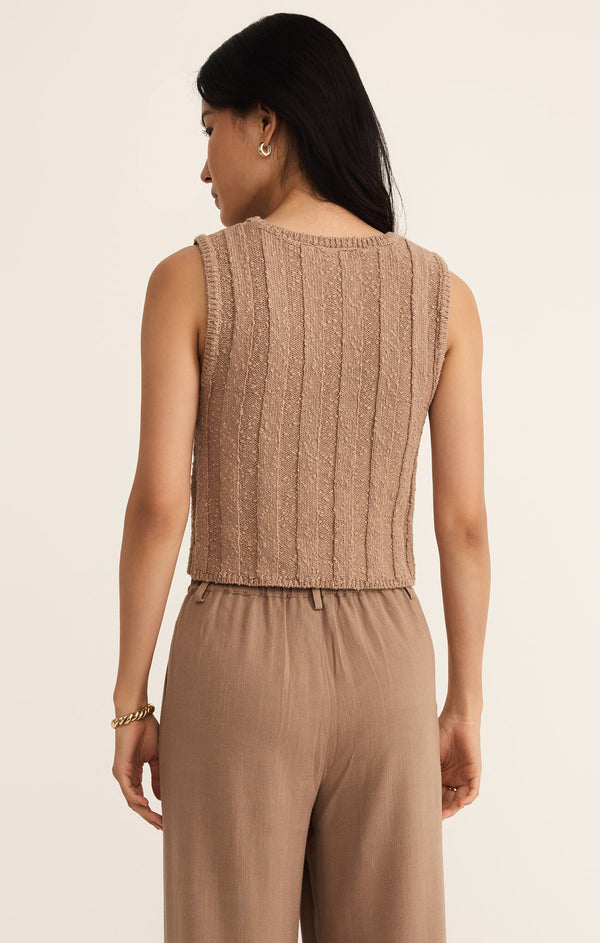 back view of the model wearing the calan top. shows the ribbed detailing. it also shows the sweater like material, the brown color and the shorter lenbgth. 