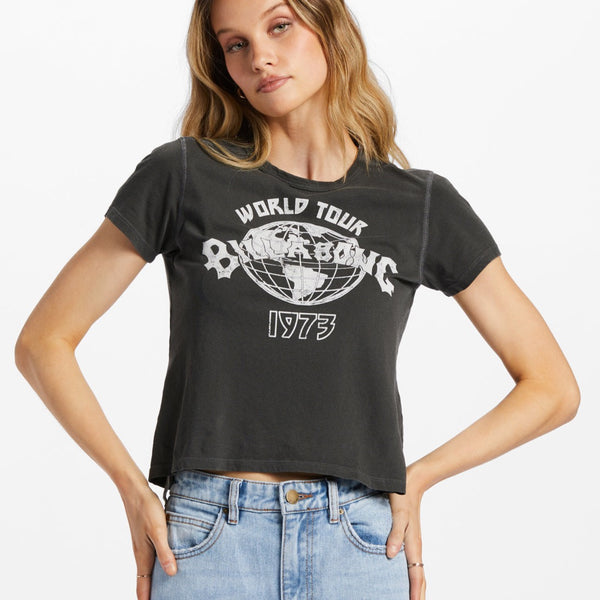 front view of model wearing world tour tee. Shows the crew neckline. Also shows the screen print on the front in white, and the short sleeves and the crop length of the t shirt. 