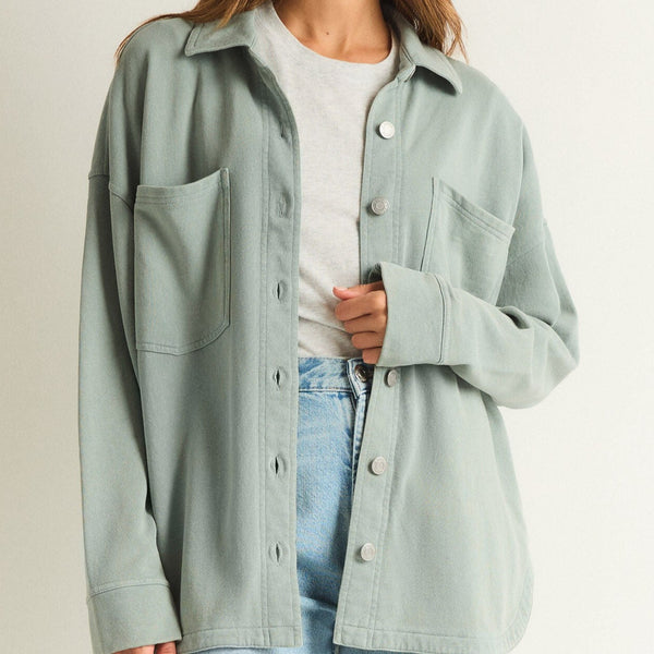 front view of the model wearing the all day knit jacket. shows the two front patch pockets. also shows the button down closure, the traditional  collar, and the dropped shoulders. 