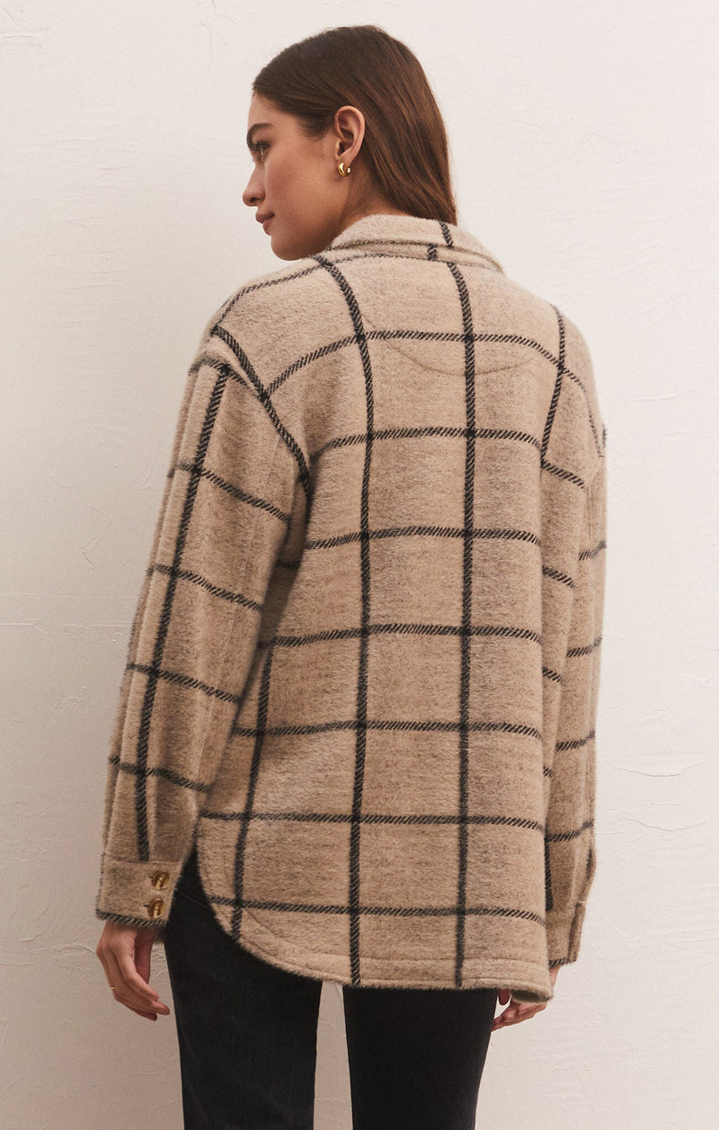front view of model in jacket. shows the plaid design, curved hemline and dropped shoulders.