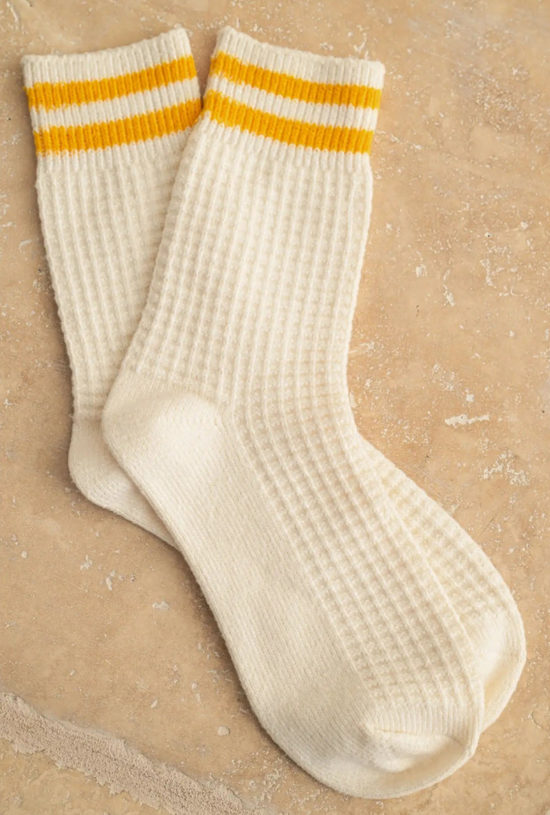White socks with yellow stripes on a beige background