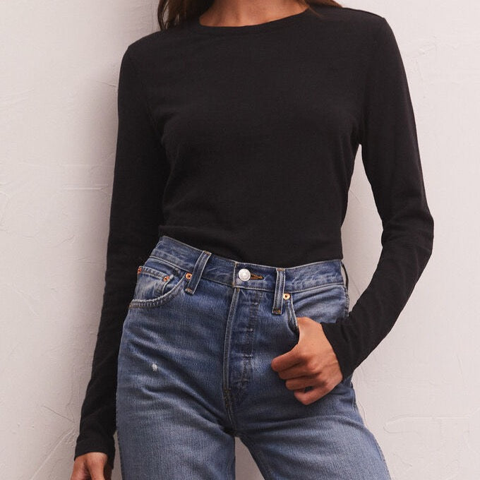 Front view of model wearing long sleeve tee.  Shows the crew neck with ribbing on the neckline. Also shows the long sleeve, slim fit. 