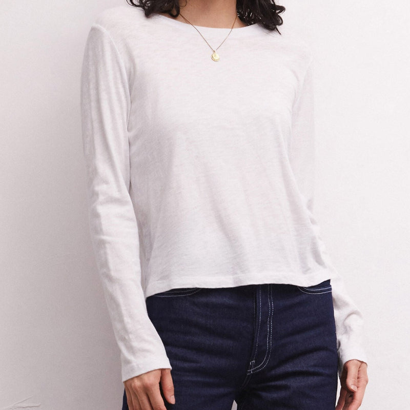 Front view of model wearing long sleeve tee. Shows the crew neck with ribbing on the neckline. Also shows the long sleeve, slim fit in this beautiful white color. 
