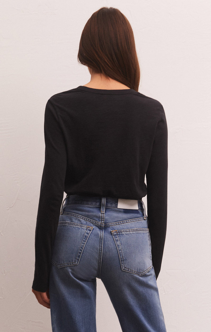 Back view of model wearing the long sleeve tee. Shows the ribbing on the neckline. Also shows the slim fit, the long sleeves in this beatiful black color. 