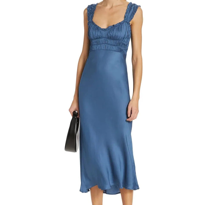 shows front view of model in blue dress. shows the sweetheart neckline with smocked straps and bust. slightly fitted through the hips and looser at the bottom.