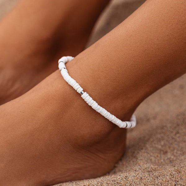 shows model wearing a stretch anklet with white and silver flat beads.