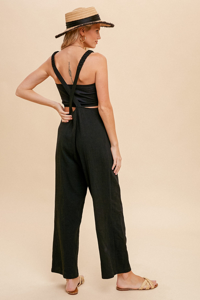 back view of model in jumpsuit. shows a criss cross back detail.