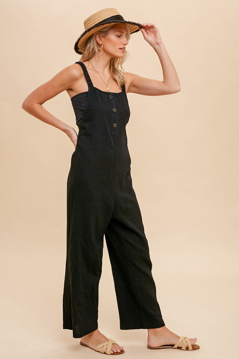 angled view of model in jumpsuit, the straight wide legs are shown and hit model at ankle. 