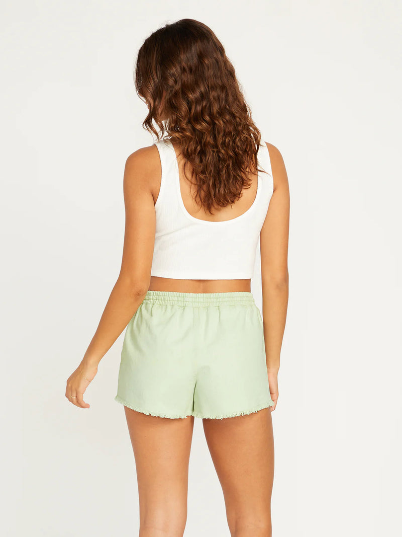 back view of model in the shorts. a plain back, no pockets and shows off the raw hem.