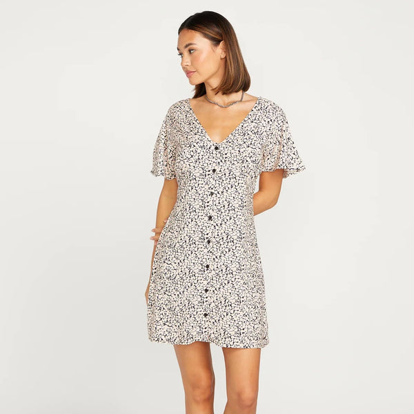 front view of model wearing the mini dress. shows a v-neckline, buttons down the front, flutter short sleeves and an all over ditsy floral print